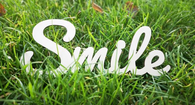 Schriftzug smile, grünes Gras